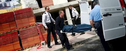 Miembros de los servicios de emergencia trasladan el cadáver del trabajador