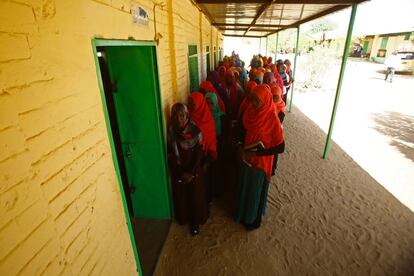 Un grupo de mujeres espera para votar en el campo de desplazados de El-Fasher, en Darfur del Norte, donde se celebra un referéndum sobre la conveniencia de mantener a sus cinco Estados o unirlos en una sola región, en Sudán.