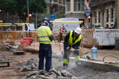 Dos operarios trabajan en el centro de Barcelona, a principios de enero.