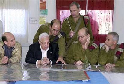 Ariel Sharon escucha explicaciones de los mandos militares israelíes, en su visita de ayer a Hebrón.