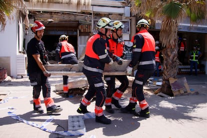 Several firefighters are busy clearing debris after the collapse of a building in Playa de Palma on May 24.