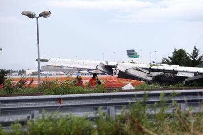 Varios operarios examinan el ala dañada de un avión de carga de la compañía DHL en el aeropuerto de Bérgamo (Italia).