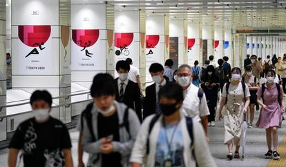 Residentes en la capital japonesa pasan ante unos carteles de los Juegos Olímpicos de Tokio 2020