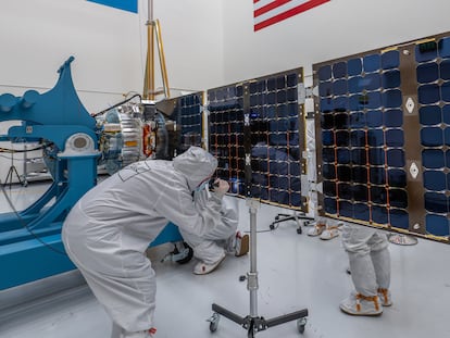Ingenieros del proyecto revisando el satélite antes del lanzamiento.