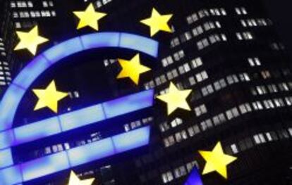 La foto muestra un signo de euro iluminado frente a la sede del Banco Central Europeo.