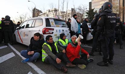 Declaraciones del portavoz de la Federación del Taxi en Madrid a la Sexta: "Solo estamos pidiendo que se cumpla la ley, queremos pedir perdón a los ciudadanos. Violencia cero". En la imagen, un grupo de taxistas, sentados en la calzada durante el bloqueo del paseo de la Castellana, este lunes.