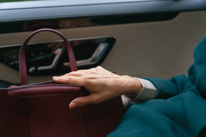 Una mujer con bolso en el asiento de un coche.