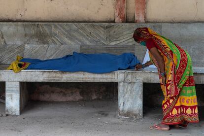 Una mujer enciende incienso junto al cuerpo sin vida de un familiar mientras espera a un vehículo para transportarlos de vuelta a su localidad y comenzar los ritos fúnebres en el hospital Lal Nehru de Jawahar, en Bhagalpur, el 29 de julio de 2020.