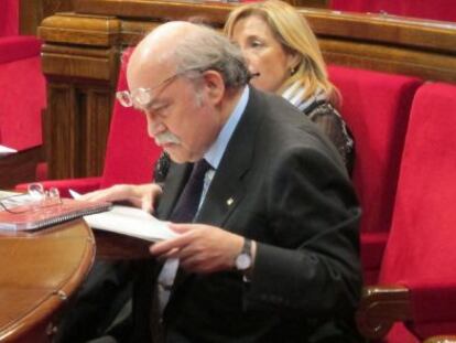 El consejero de Economía, Andreu Mas-Colell, revisa documentación en el escaño del Parlament.