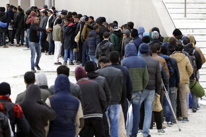 People queue for food at a former Olympic indoor stadium in Faliro, southern Athens, on Friday, Dec. 11, 2015. Hundreds of migrants have been temporarilyy housed in the stadium after being removed this week from Greece's northern border with Macedonia, which only allows Syrians, Afghans and Iraqis through on their trek to wealthier European countries _ rejecting others as economic migrants who do not merit refugee protection. Greek authorities have urged migrants who can't continue north to seek asylum in Greece or return home. (AP Photo/Thanassis Stavrakis)