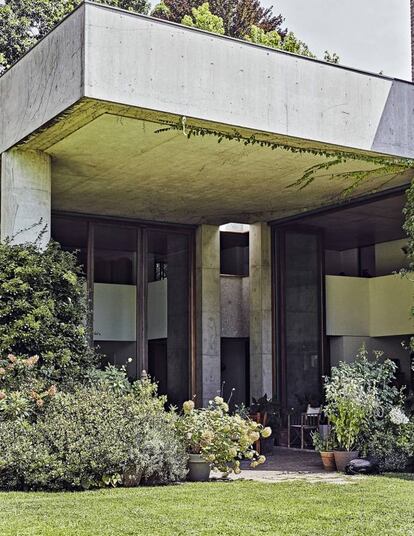 Una vista frontal del porche que articula la fachada principal de la casa. La vegetación fue una elección deliberada: cuando se construyó, el edificio se veía demasiado.