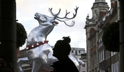 Un peatón pasa ante un reno gigante en Covent Garden, Londres.