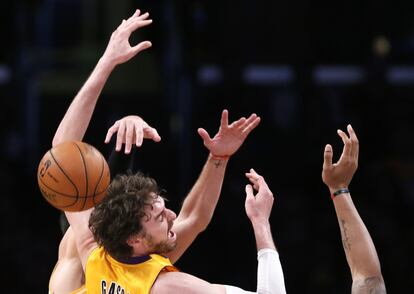 Pau Gasol lucha por el balón con dos rivales de los Rockets.