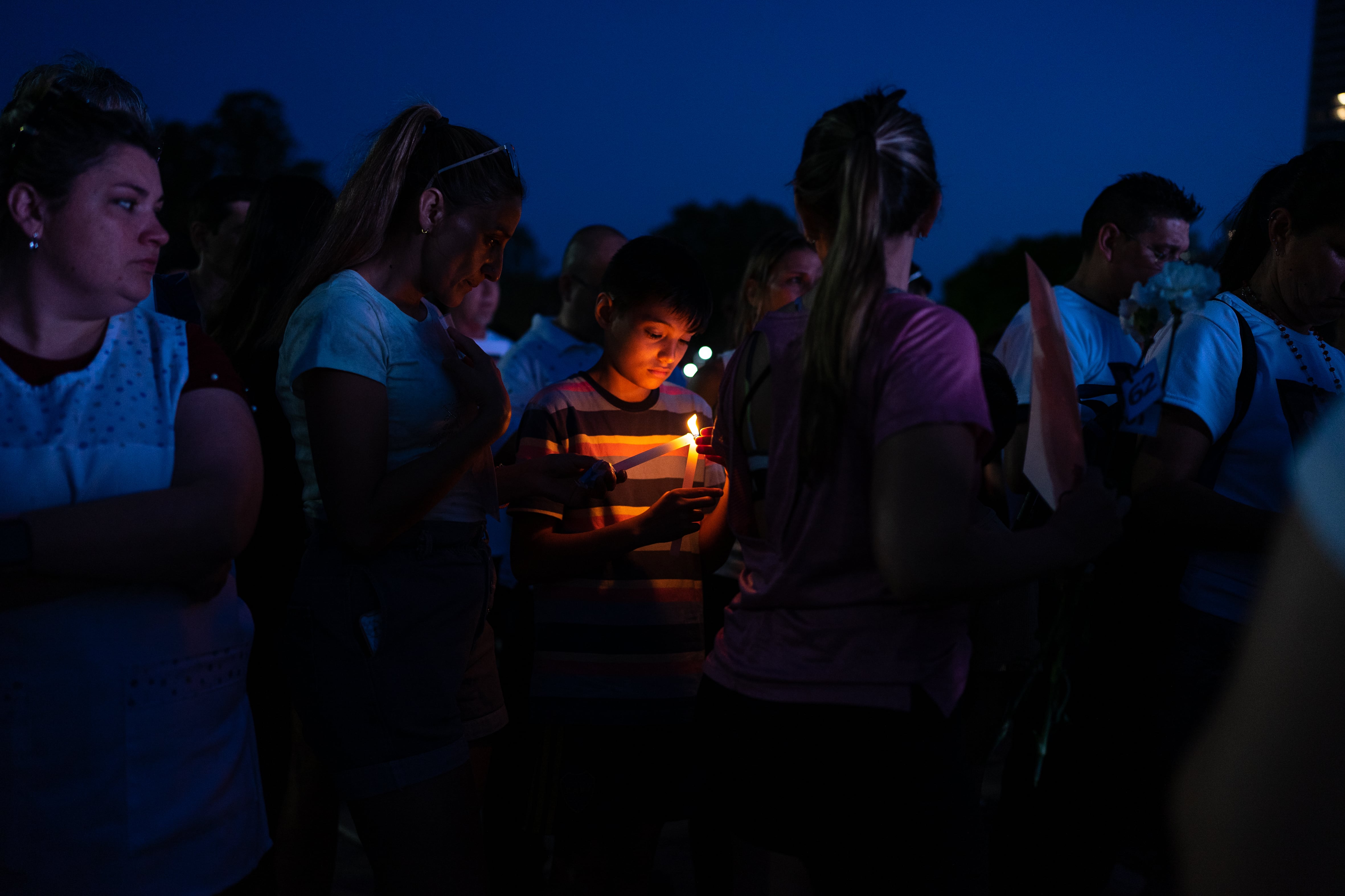 Un niño observa la llama de una vela encendida en memoria de las víctimas del fentanilo contaminado.