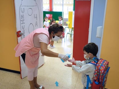 En la imagen, una profesora pone gel desinfectante en las manos a un niño en el colegio Millares Carló de Puerto del Rosario (Fuerteventura).