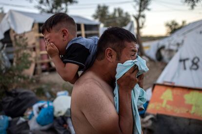 Un hombre y un niño lloran después de que la policía dispare gases lacrimógenos durante enfrentamientos en el campo de refugiados de Moria en la isla griega de Lesbos. La Agencia de Noticias de Atenas ha informado de que una mujer y un niño murieron en el incendio del campamento este pasado domingo, 29 de septiembre. El fuego dentro del campamento ha sido extinguido, pero la policía disparó gases lacrimógenos para disipar la agitación y el enfado de quienes se hallaban en él.