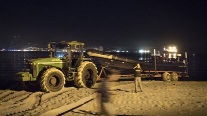 A tractor hauls a drug boat on Playa de Palmones.