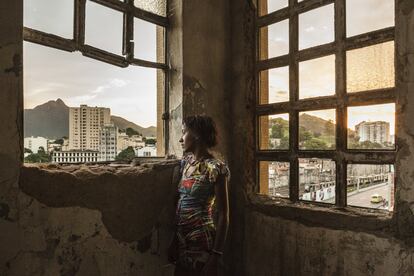 Mulher em frente às janelas do edifício abandonado do Ministério da Fazenda na favela da Mangueira, situada na zona norte do Rio de Janeiro, a menos de um quilômetro do estádio do Maracanã, epicentro da Copa do Mundo de futebol e dos Jogos Olímpicos do Rio de Janeiro.