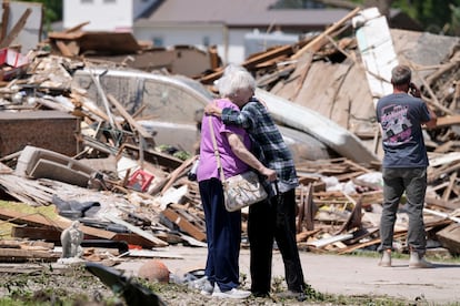 Joan Mitchell recibe un abrazo de su vecina Edith Schaecher frente a sus casas dañadas por el tornado en Iowa. 