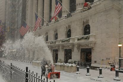 Um trabalhador limpa a neve em frente a edifício de Nova York (EUA). Em Washington, na quarta-feira, o aeroporto Dulles, nos arredores da capital, registrou uma mínima histórica de 17 graus centígrados abaixo de zero. Rajadas de vento de até 40 quilômetros por hora farão com que a sensação térmica em toda a região nordeste possa baixar entre três e cinco graus mais.