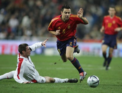 Xavi, con Jamie Carragher, en una jugada del partido amistoso que enfrentó a las selecciones de España e Inglaterra, en el estadio Santiago Bernabéu, encuentro disputado con motivo de los 500 partidos de la Selección.