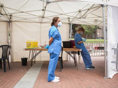 Dos enfermeras esperan a que lleguen personas para vacunar en la plaza Roja de Ciutat Meridiana, en Barcelona.