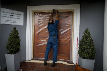 Un trabajador construye una barrera transparente para que los visitantes puedan ver a los ancianos en la residencia Reminiscencias en Tandil, Argentina, este lunes.