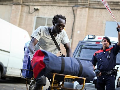 Un hombre migrante y un agente de los 'mossos' en el desalojo de decenas de inmigrantes asentados en naves industriales abandonadas del distrito de Poblenou en Barcelona en julio de 2013.