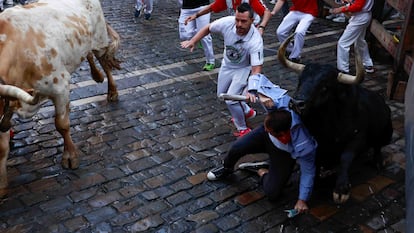 A runner is brought down by a skidding bull at the second 'encierro' of the Sanfermines festival in Pamplona on Monday morning.