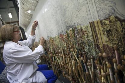 One of the workers at the factory sketches out a tapestry.