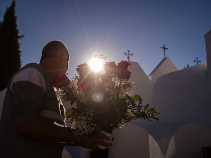 Un hombre sujeta un ramos de rosas en el cementerio de Casabermeja (Málaga), este miércoles.