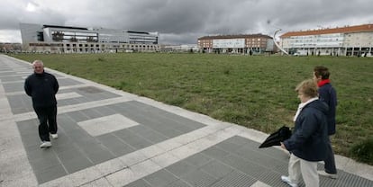 Un grupo de paseantes, junto a la parcela de la plaza de Euskaltzaindia, una de las opciones de Vitoria para construir su estación de autobuses.