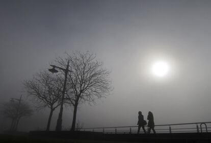 Unas personas cruzan un parque a lo largo del río Hudson en Manhattan.