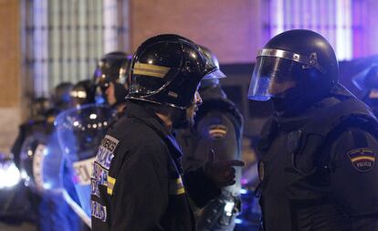 Uno de los bomberos que ha participado en la manifestación de Madrid conversa al final de la marcha con un policía nacional en las inmediaciones del Congreso de los Diputados