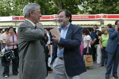 Mario Vargas Llosa, a la izquierda, conversa con Juan Luis Cebrián, ayer en la Feria del Libro.