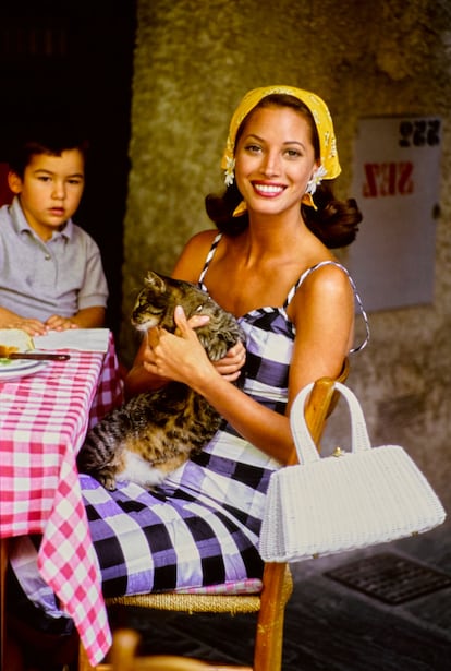 Christy Turlington en Portofino, 1992. La foto es la postal de verano perfecta y una de las imágenes por las que la costa amalfitana sigue siendo el sueño de muchos veraneantes tres décadas después: la supermodelo Christy Turlington, pelando frutas y verduras en las calles de Portofino. Tomada por Arthur Elgort, la fotografía evoca el espíritu mediterráneo también a través de la ropa: con un look de Escada diseñado por Margaretha Ley, Turlington lleva un pañuelo atado en la cabeza, lo que le da un aire bohemio y relajado, pero también cinematográfico. (Arthur Elgort/Conde Nast via Getty Images)