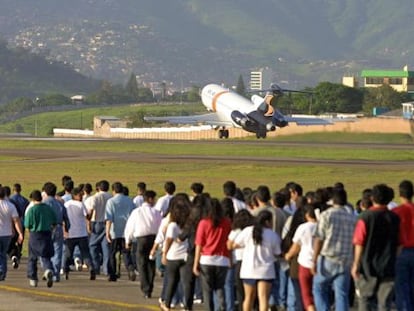 Un grupo de hondure&ntilde;os deportados desde EE UU camina por la pista del aeropuerto de Tegucigalpa. 