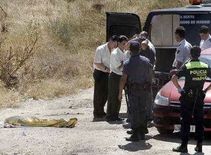 La policía y varios empleados de los servicios funerarios, ante el cadáver de la víctima.