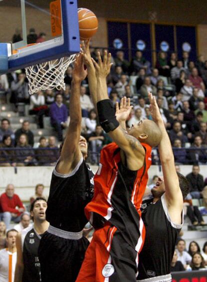 Salva Guardia trata de impedir la canasta de Chris Moss.