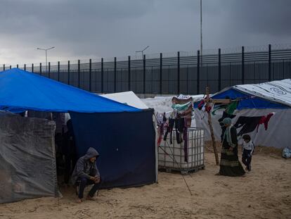 Palestinians displaced by the Israeli air and ground offensive on the Gaza Strip walk through a makeshift tent camp in Rafah on the border with Egypt, Jan. 27, 2024. 