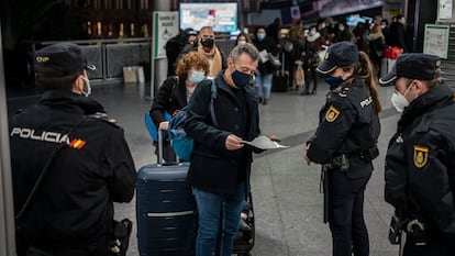 Travelers passing through police controls at Madrid’s Atocha train station.