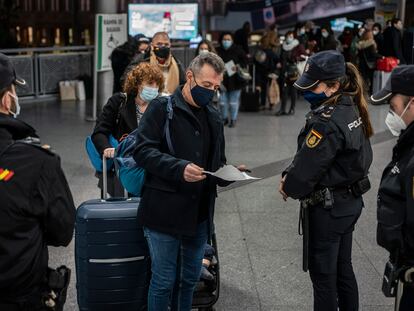 Travelers passing through police controls at Madrid’s Atocha train station.