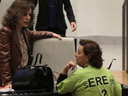 Durante el pleno municipal, varios concejales de IU se han vestido con una camiseta para protestar por los despidos en la empresa municipal Madridec. En la imagen, Milagros Hernández habla con la alcaldesa.