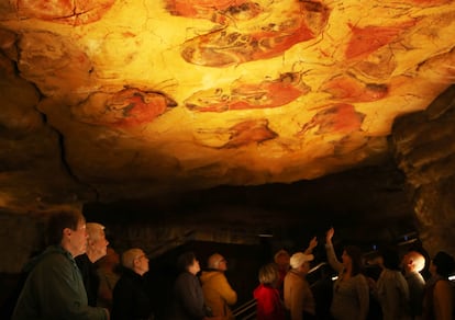 Varias personas visitan la neocueva, una reproducción de la cueva de Altamira, en Cantabria.