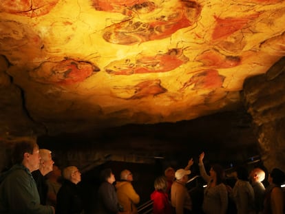 Varias personas visitan la neocueva, una reproducción de la cueva de Altamira, en Cantabria.