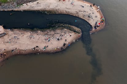 La gente pesca junto al drenaje que desemboca en el río Paraguay de Asunción, el 28 de enero de 2024.