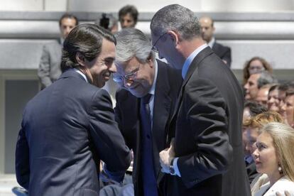 Los expresidentes José María Aznar y Felipe González se saludan frente a Alberto Ruiz-Gallardón.