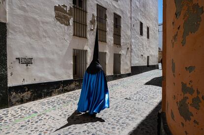 Una penitente en su camino a una procesión en las calles de Cádiz este Viernes Santo. En la ciudad andaluza hay procesiones antiquísimas como la Veracruz, que data de 1566. Vivir el encuentro de las imágenes con sus devotos constituye una experiencia extraordinaria. El rezo en silencio, la saeta cantada desde un balcón, el ruido de las cadenas en los tobillos y los tambores, trompetas y cornetas marcando el paso de una procesión trastocan los sentidos.