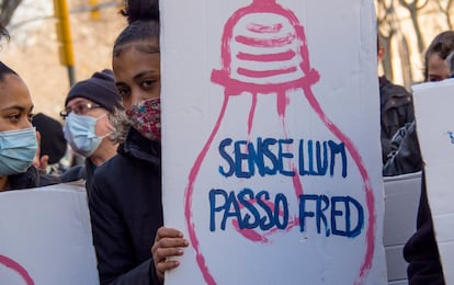 Una vecina del Raval durante la protesta muestra un cartel: "Sin luz paso frío".