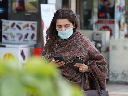 A woman uses her phone on a street in Islamabad, Pakistan in 2020.